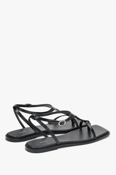 Schwarze flache Damen-Sandalen mit Zehentrenner in schräger Seitenansicht