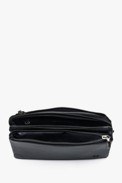 Draufsicht auf die geöffnete schwarze Leder-Clutch, die die drei aufgefächerten Hauptfächer zeigt