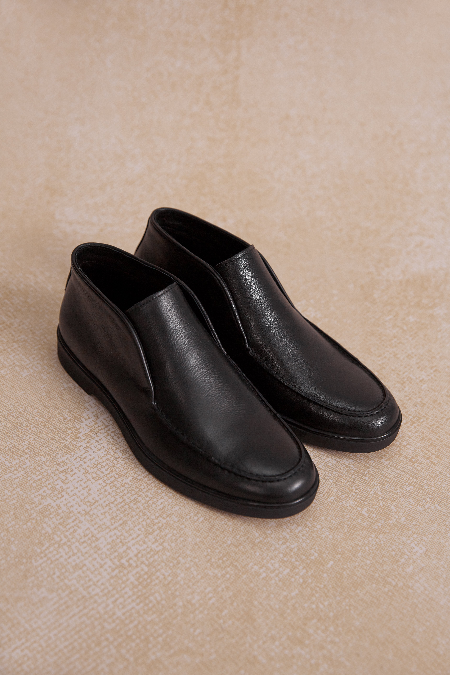 Schwarze Herren-Slipper aus weichem Glattleder.