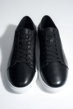 Draufsicht auf das Paar schwarzer Herren-Sneaker aus weichem Echtleder.
