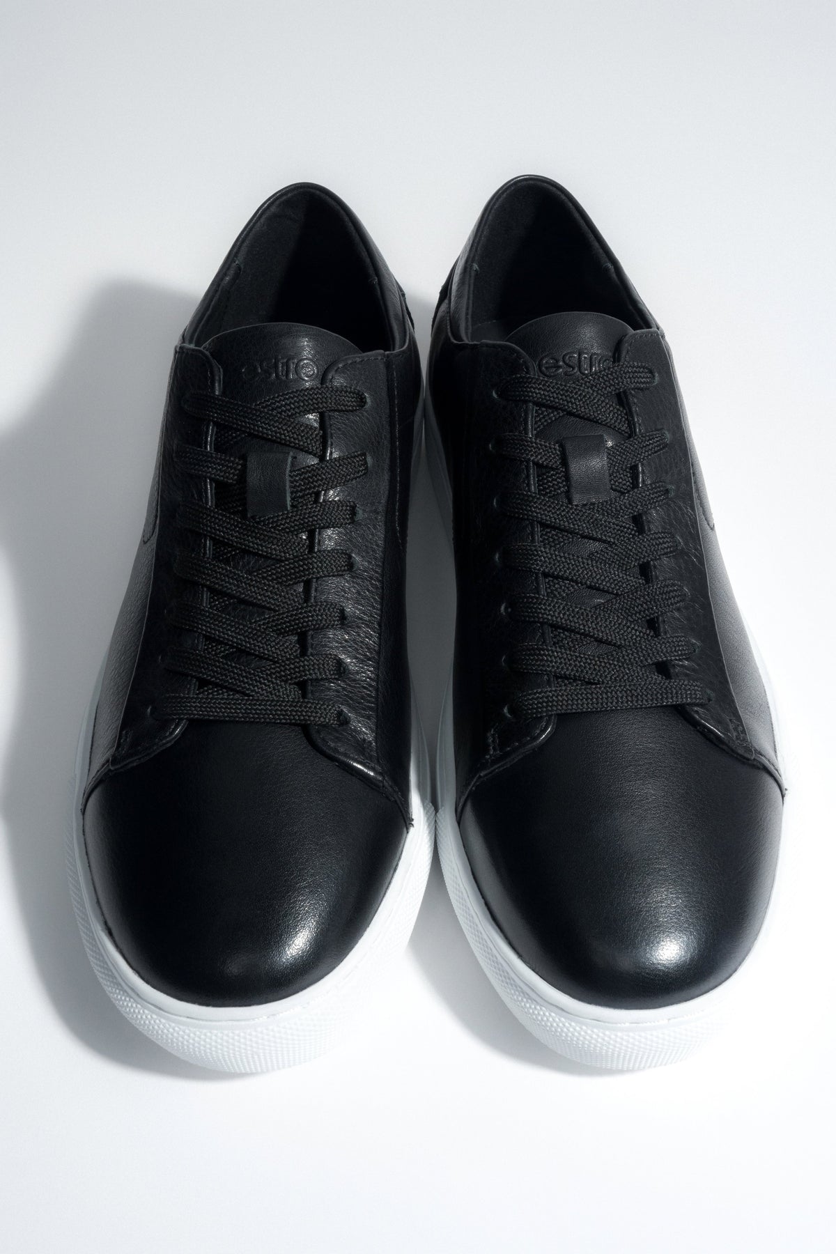 Draufsicht auf das Paar schwarzer Herren-Sneaker aus weichem Echtleder.