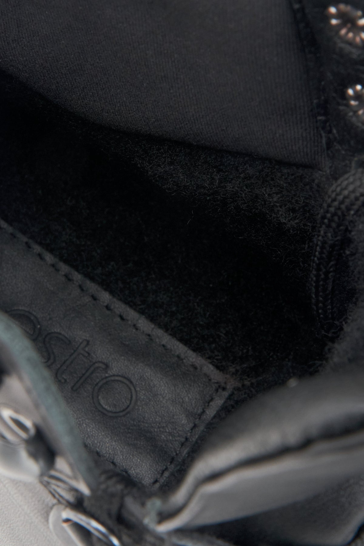 Nahaufnahme des weichen Textilkragens und des wärmenden Synthetikfutters im Inneren der schwarzen Stiefelette