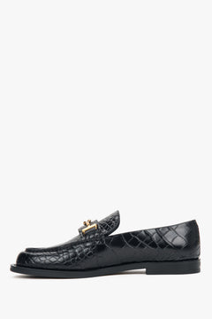 Klassische schwarze Slipper aus Glattleder mit dekorativem Metallelement. 