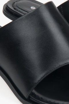 Minimalistische schwarze Leder-Sandaletten mit Zehensteg und Pfennigabsatz.