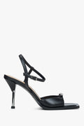Rechte Seitenansicht der schwarzen Stiletto-Sandalette mit silbernem Absatz und auffälliger Front-Schnalle