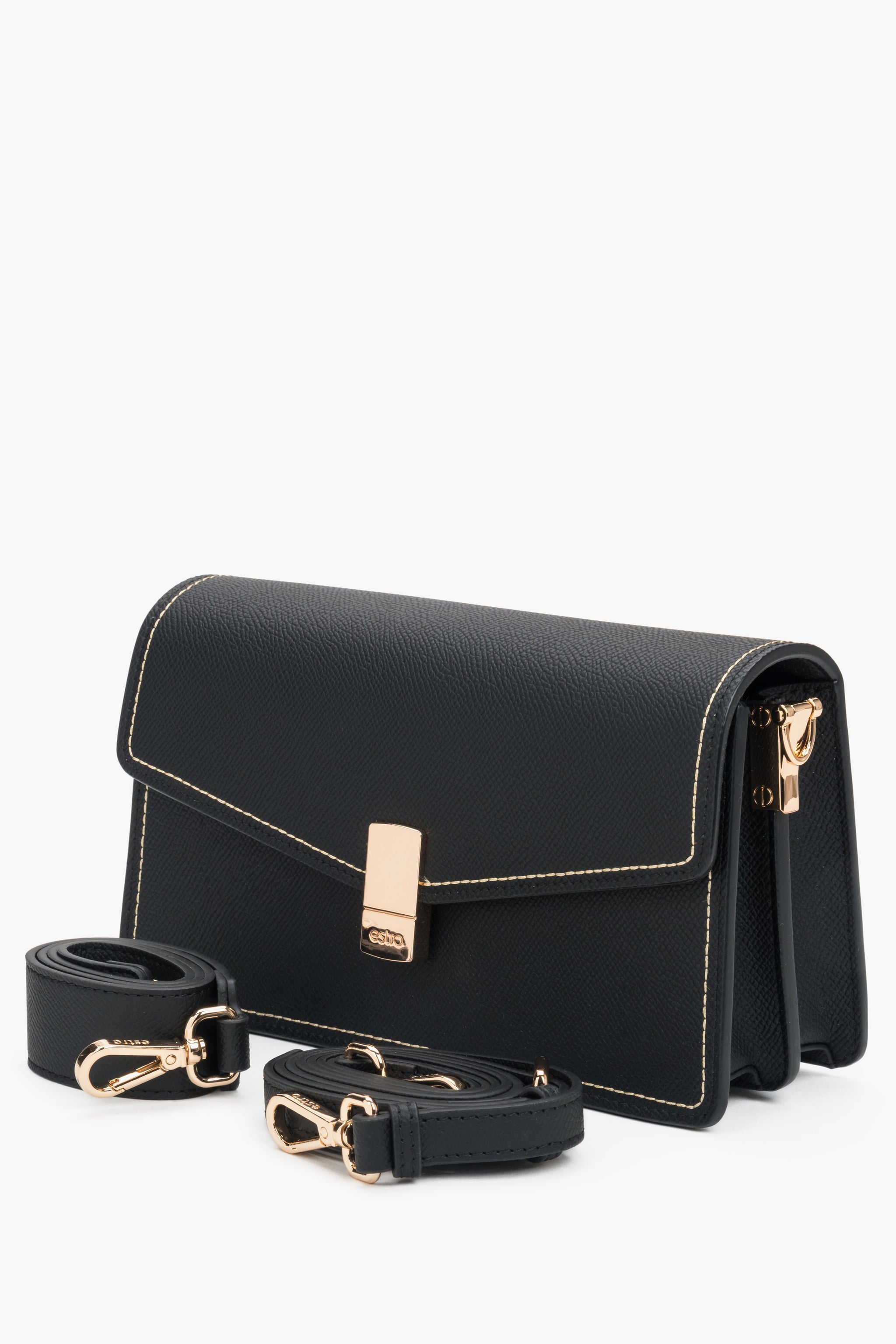 Nahaufnahme der glänzenden goldenen Beschläge an der schwarzen Handtasche.