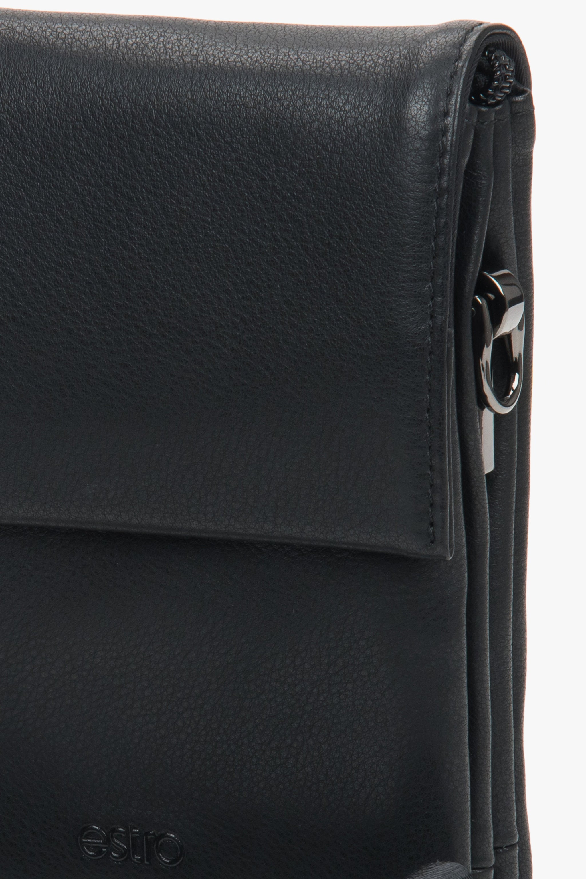 Nahaufnahme der Lederstruktur, des dezent geprägten Logos und des verchromten Karabiners der schwarzen Tablet-Tasche