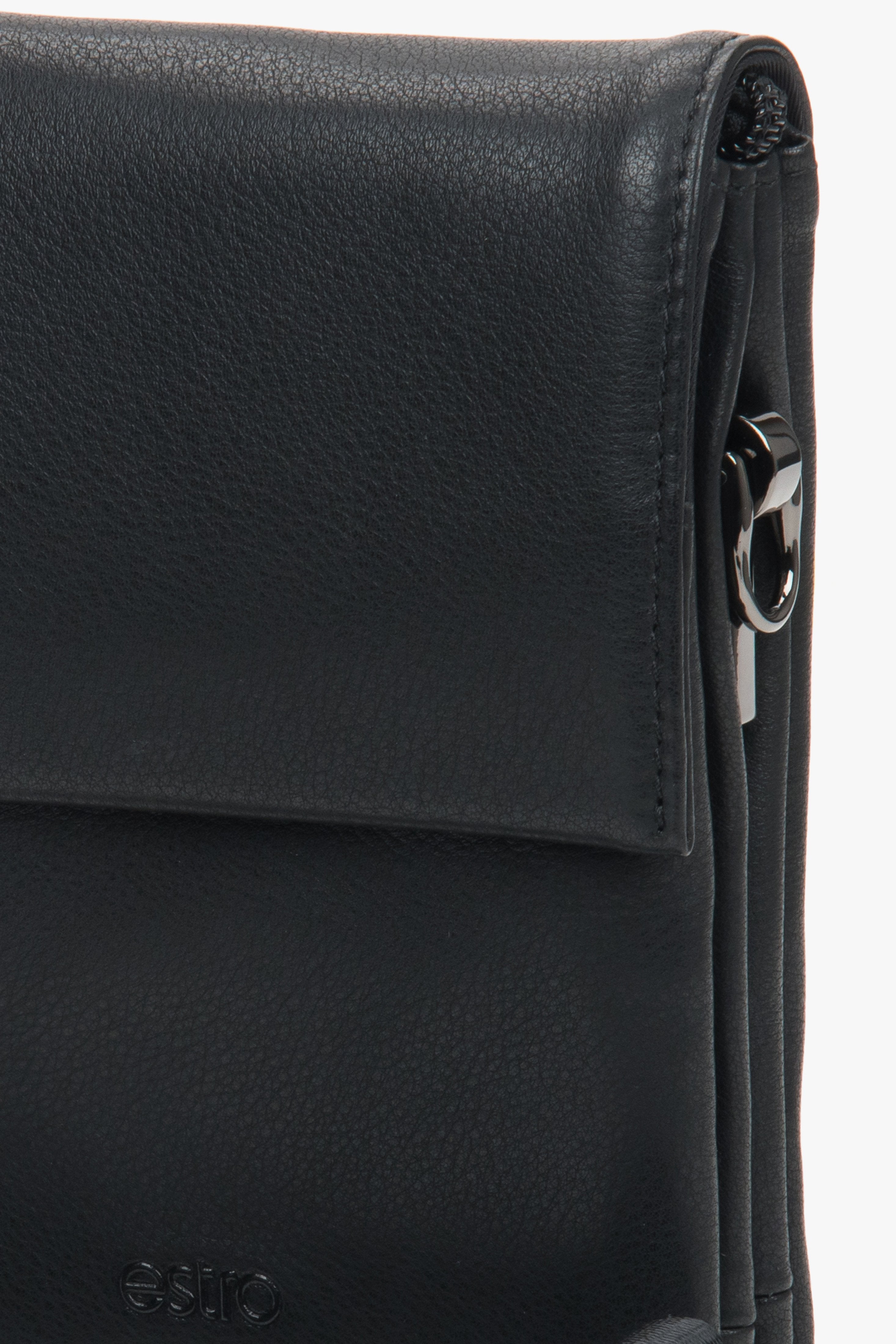 Nahaufnahme der Lederstruktur, des dezent geprägten Logos und des verchromten Karabiners der schwarzen Tablet-Tasche