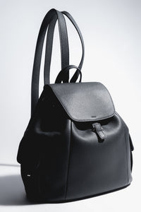 Künstlerische Profilansicht des schwarzen Damen-Beutelrucksacks aus genarbtem Leder