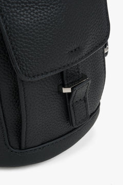Nahaufnahme der eleganten Überschlagklappe mit dezenter Logo-Prägung auf dem genarbten Leder