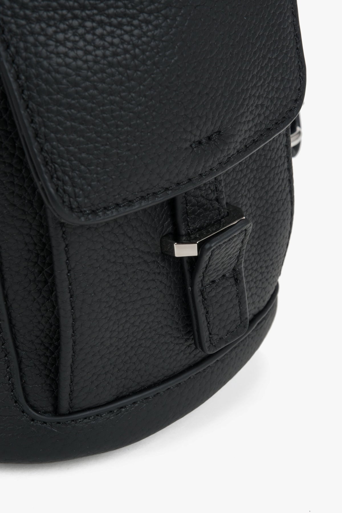 Nahaufnahme der eleganten Überschlagklappe mit dezenter Logo-Prägung auf dem genarbten Leder