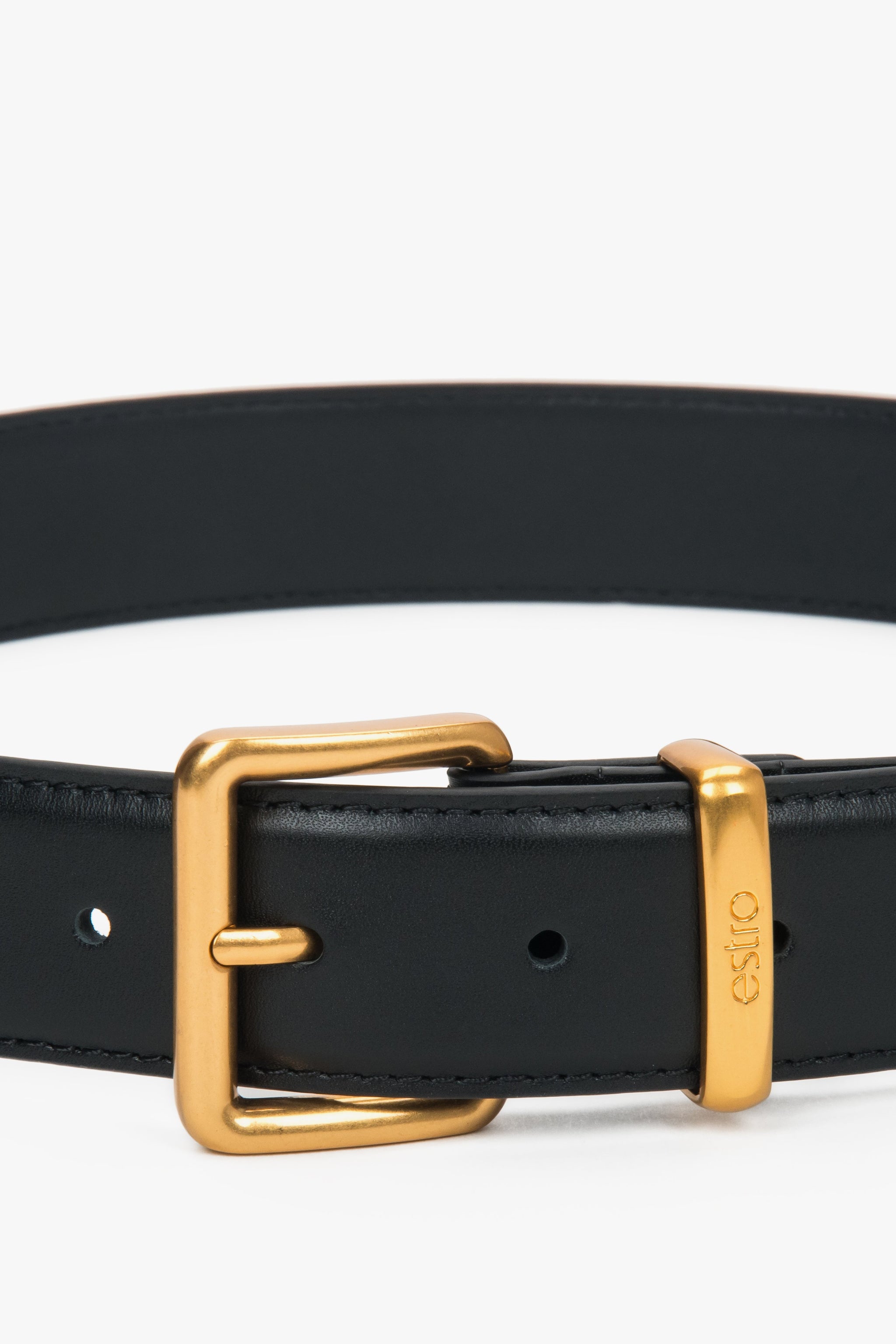 Nahaufnahme der eleganten, goldenen Dornschnalle und der Lederschlaufe mit Logo 