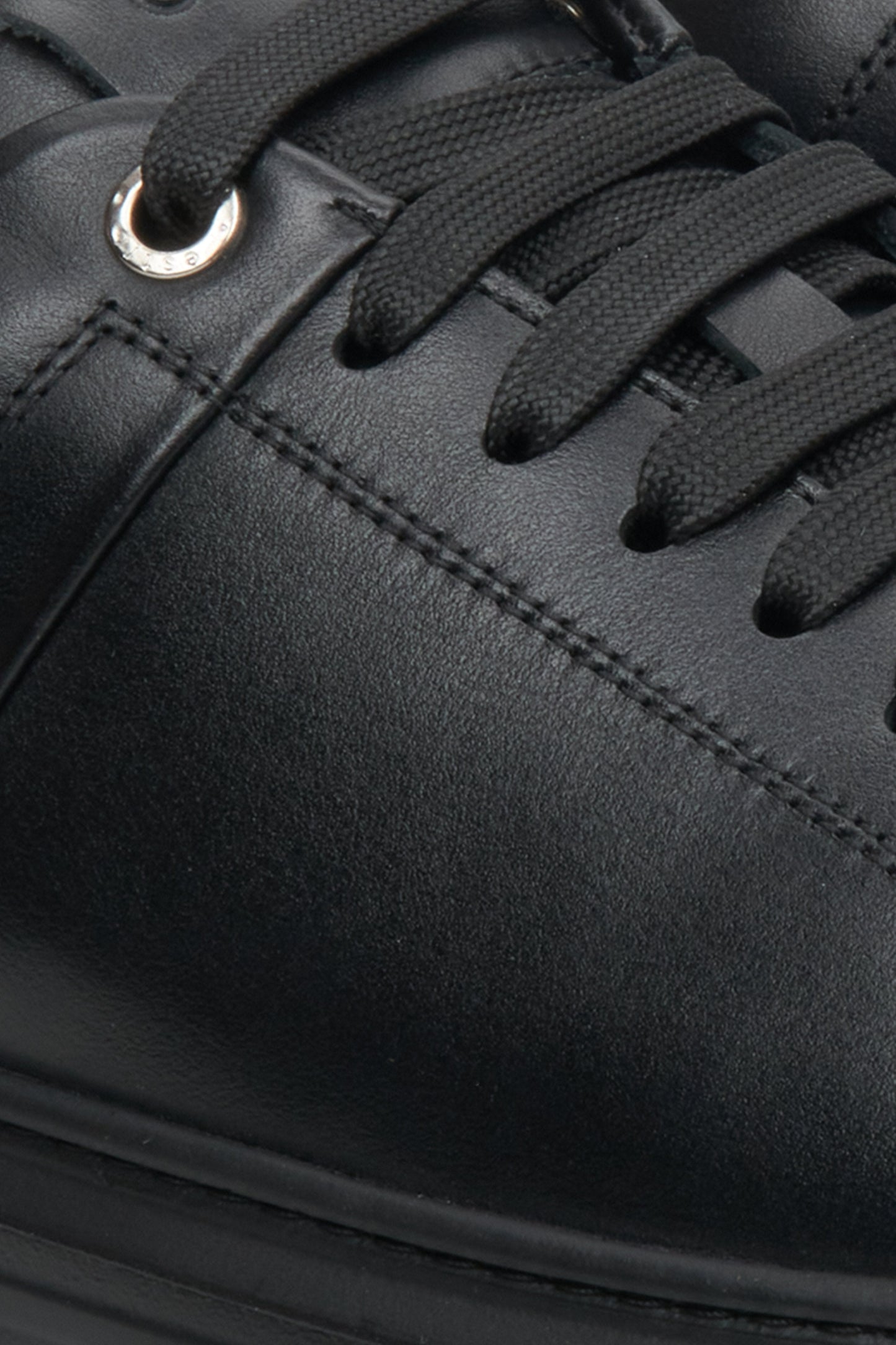 Flache schwarze Estro Herren-Sneaker mit Schnürung – Nahaufnahme von Ferse und Seitenlinie.