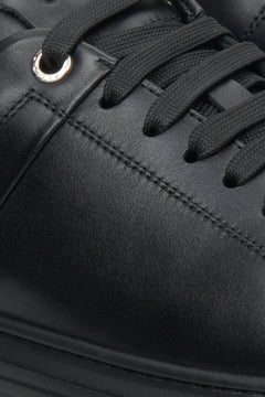 Flache schwarze Estro Herren-Sneaker mit Schnürung – Nahaufnahme von Ferse und Seitenlinie.