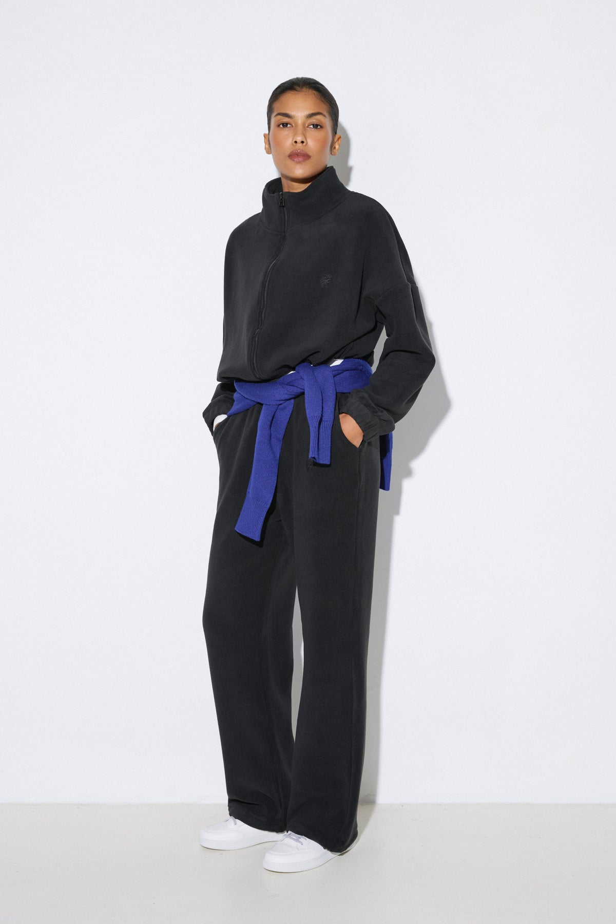 Seitenprofil des schwarzen Damen-Fleece-Sets, das die sportliche Silhouette und die bequeme Passform zeigt