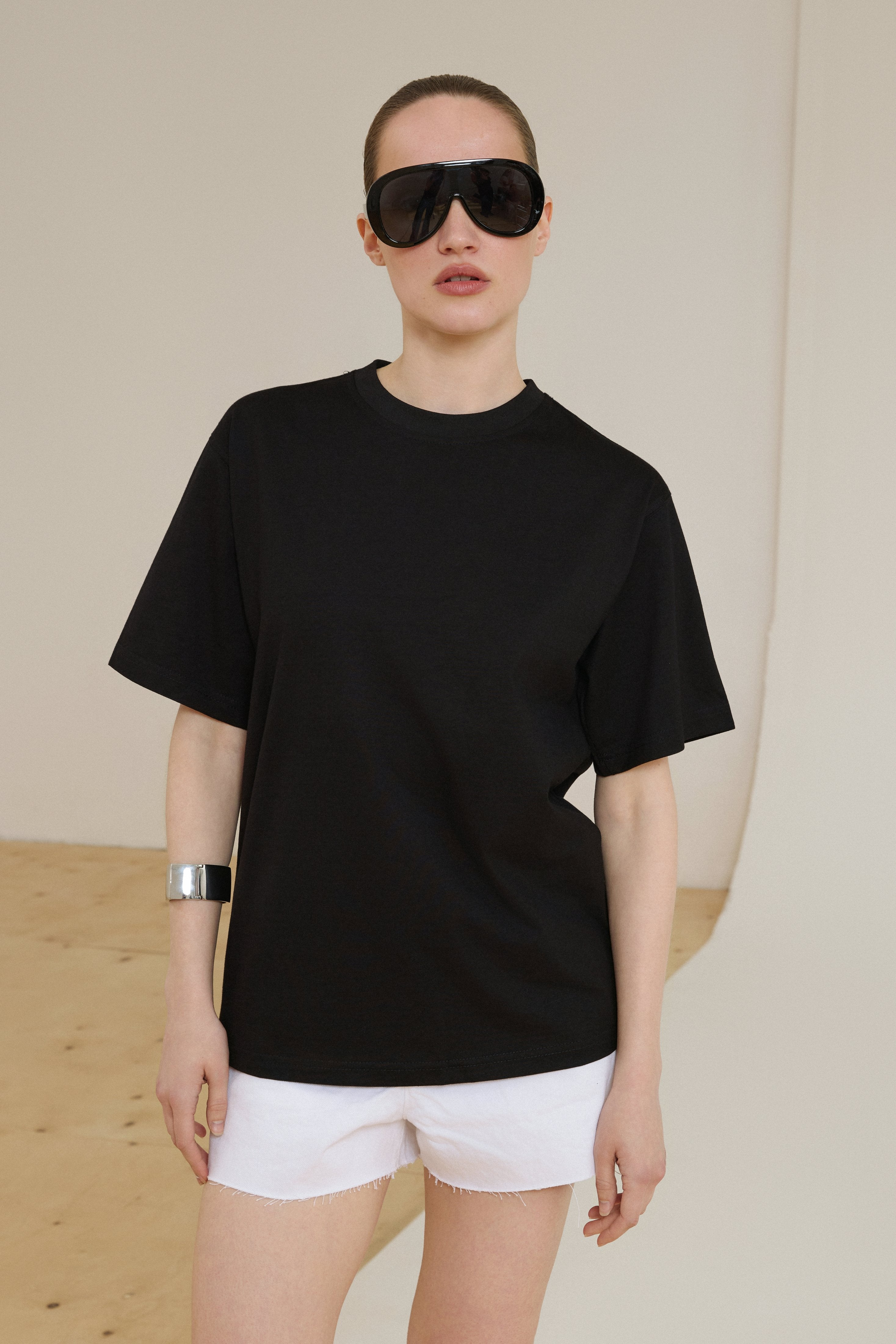 Schwarzes Damen-T-Shirt mit überschnittenen Schultern am Model Detailansicht