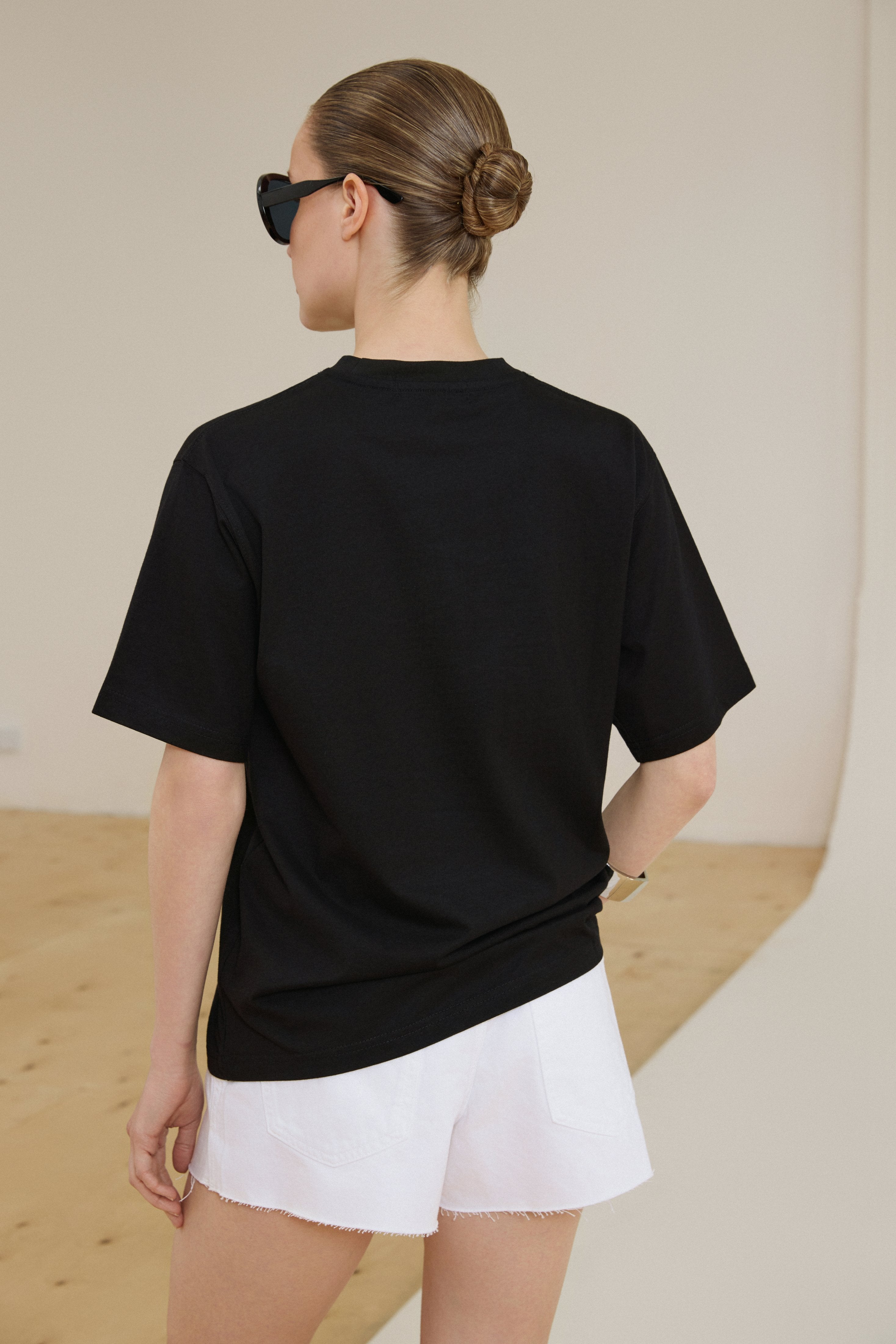 Rückansicht des schwarzen Baumwoll-T-Shirts im Boxy-Schnitt am Model