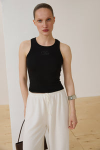 Model trägt schwarzes Damen-Tanktop aus gerippter Baumwolle Vorderansicht