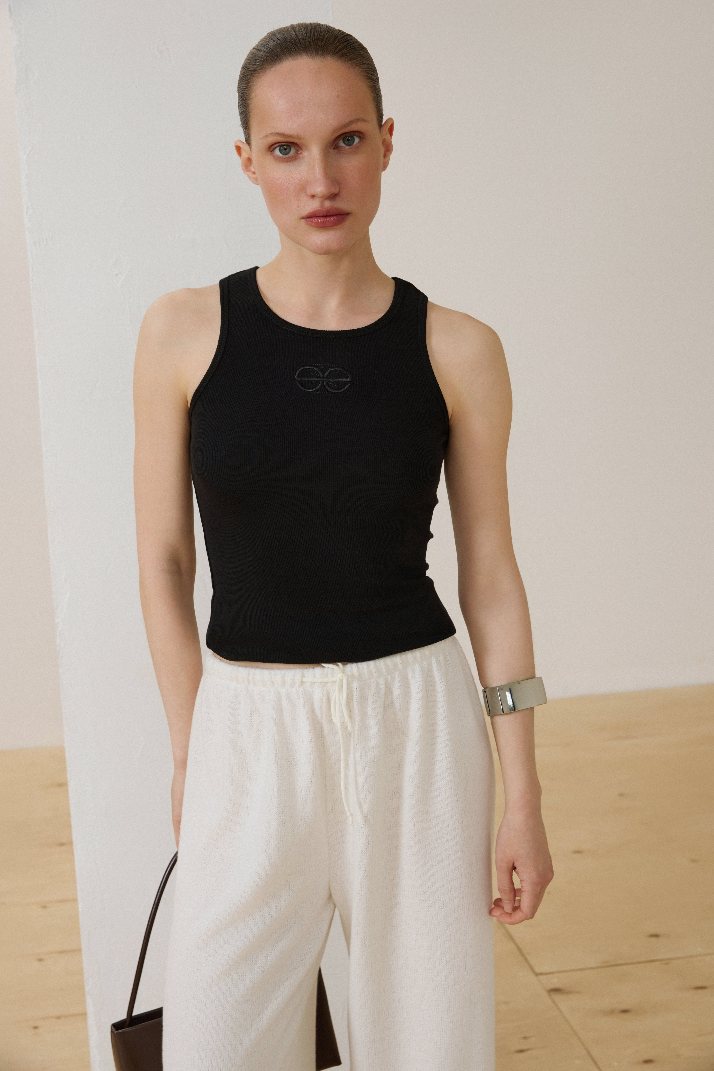 Model trägt schwarzes Damen-Tanktop aus gerippter Baumwolle Vorderansicht