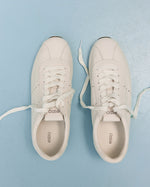 Damen-Sneaker aus weichem weißen Leder mit flacher Sohle von Estro – Ansicht von oben.