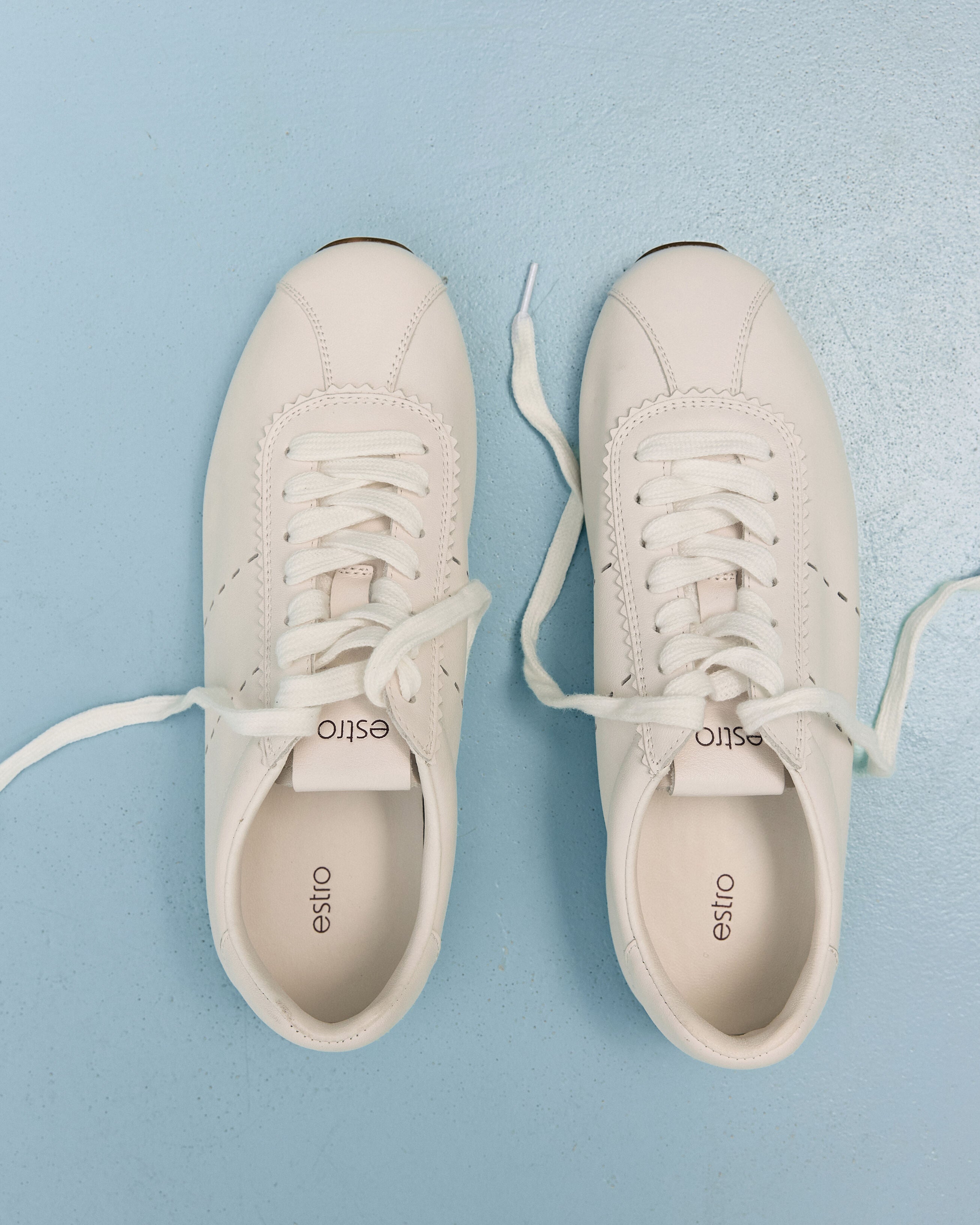 Damen-Sneaker aus weichem weißen Leder mit flacher Sohle von Estro – Ansicht von oben.
