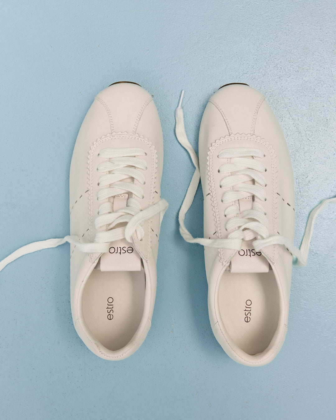 Damen-Sneaker aus weichem weißen Leder mit flacher Sohle von Estro – Ansicht von oben.