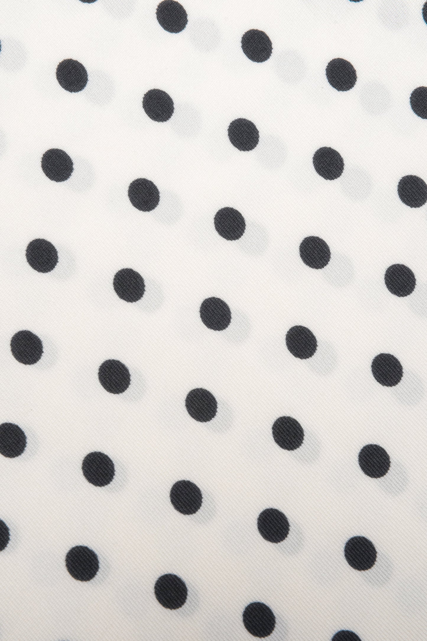 Detailaufnahme des feinen Stoffes und des zeitlosen weiß-schwarzen Polka-Dot-Musters