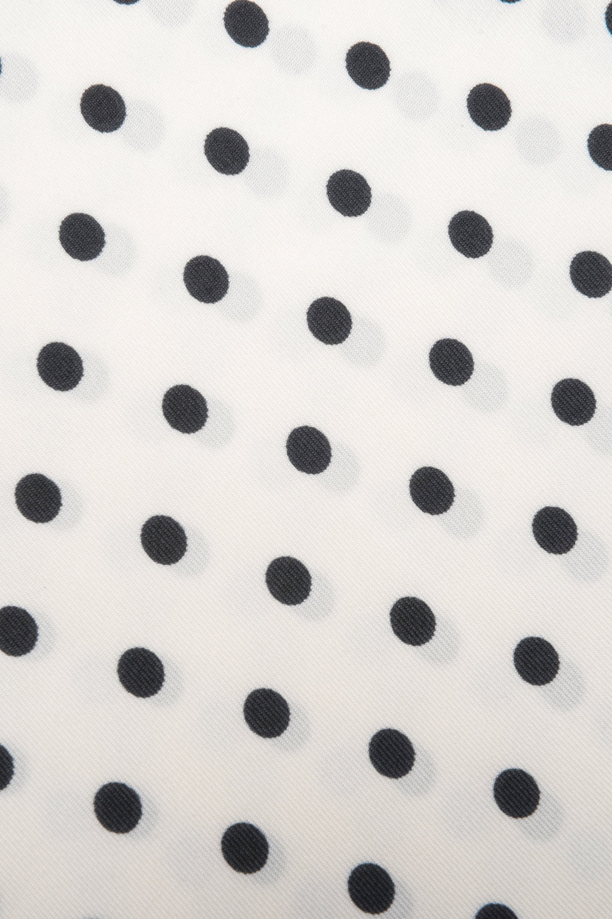 Detailaufnahme des feinen Stoffes und des zeitlosen weiß-schwarzen Polka-Dot-Musters