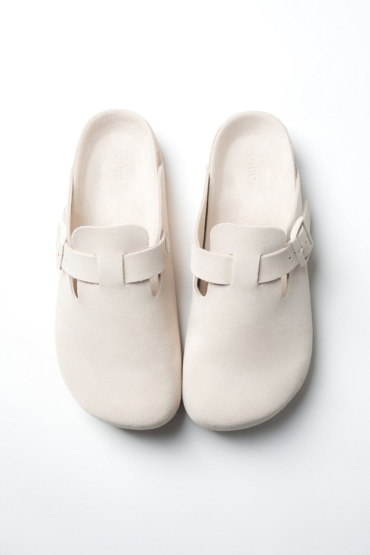 Draufsicht auf das Paar weißer Damen-Mules im Clog-Stil aus Velours.