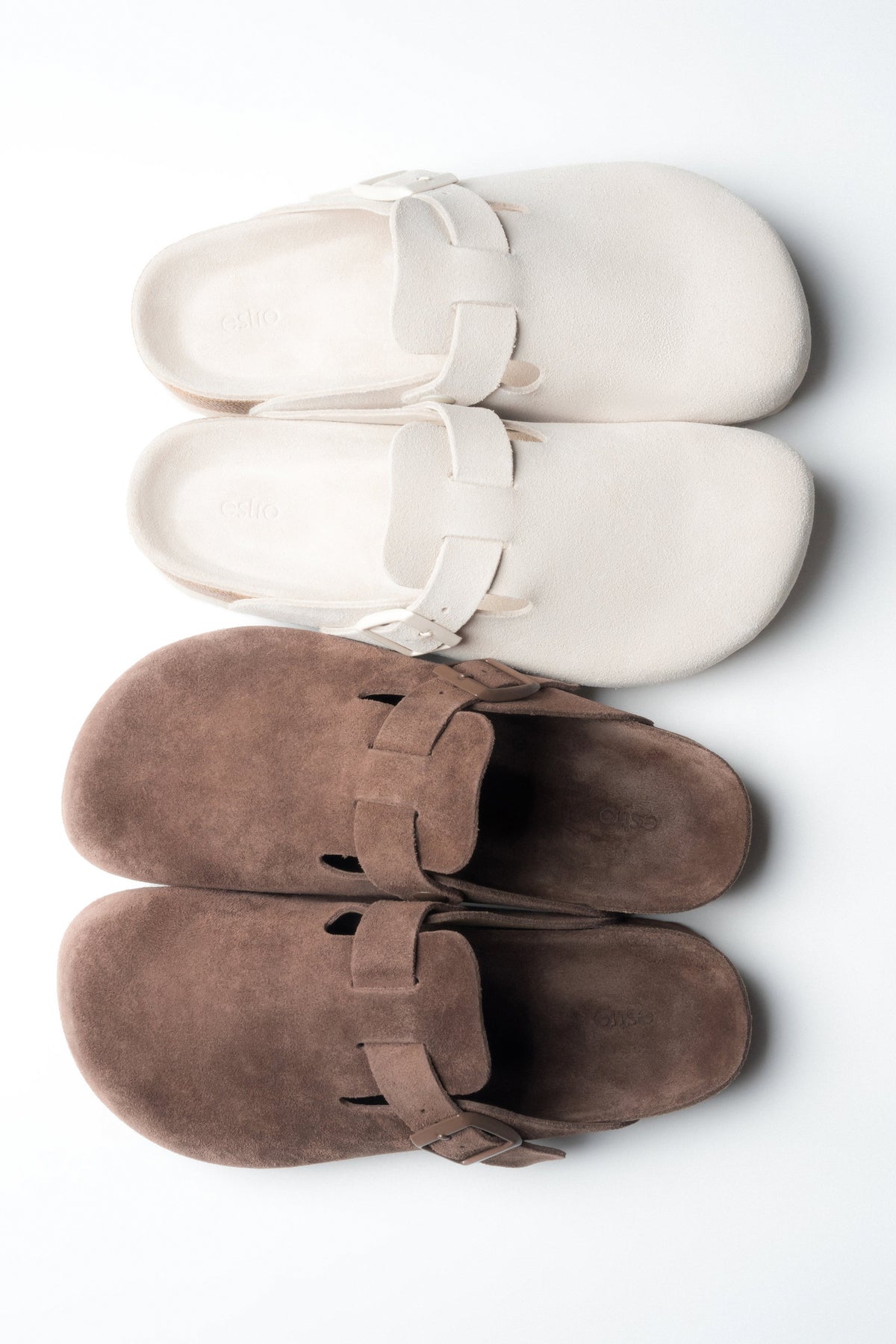 Zwei Paar Damen-Clogs in Weiß und Braun in der gemeinsamen Draufsicht.