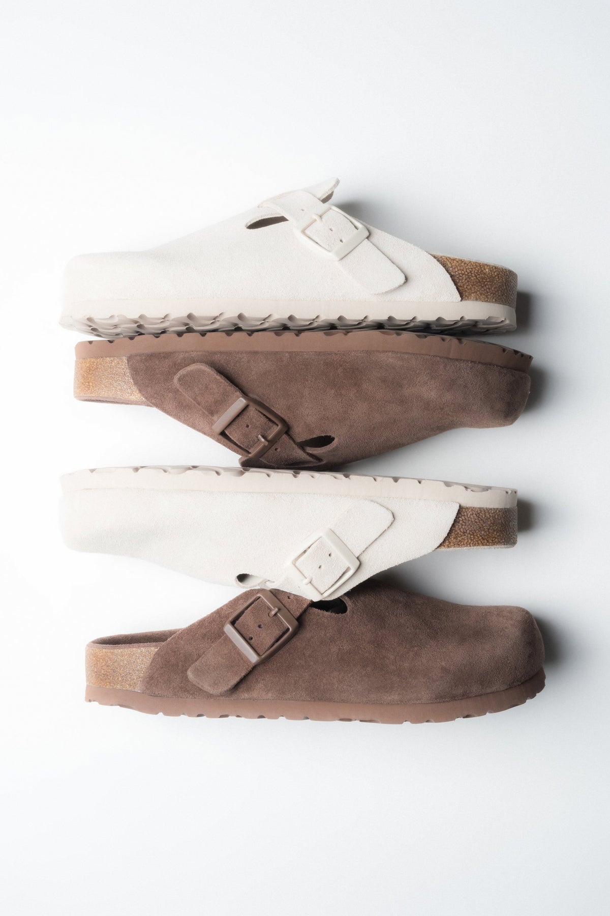 Kombination aus weißen und braunen Damen-Clogs aus weichem Naturvelours.