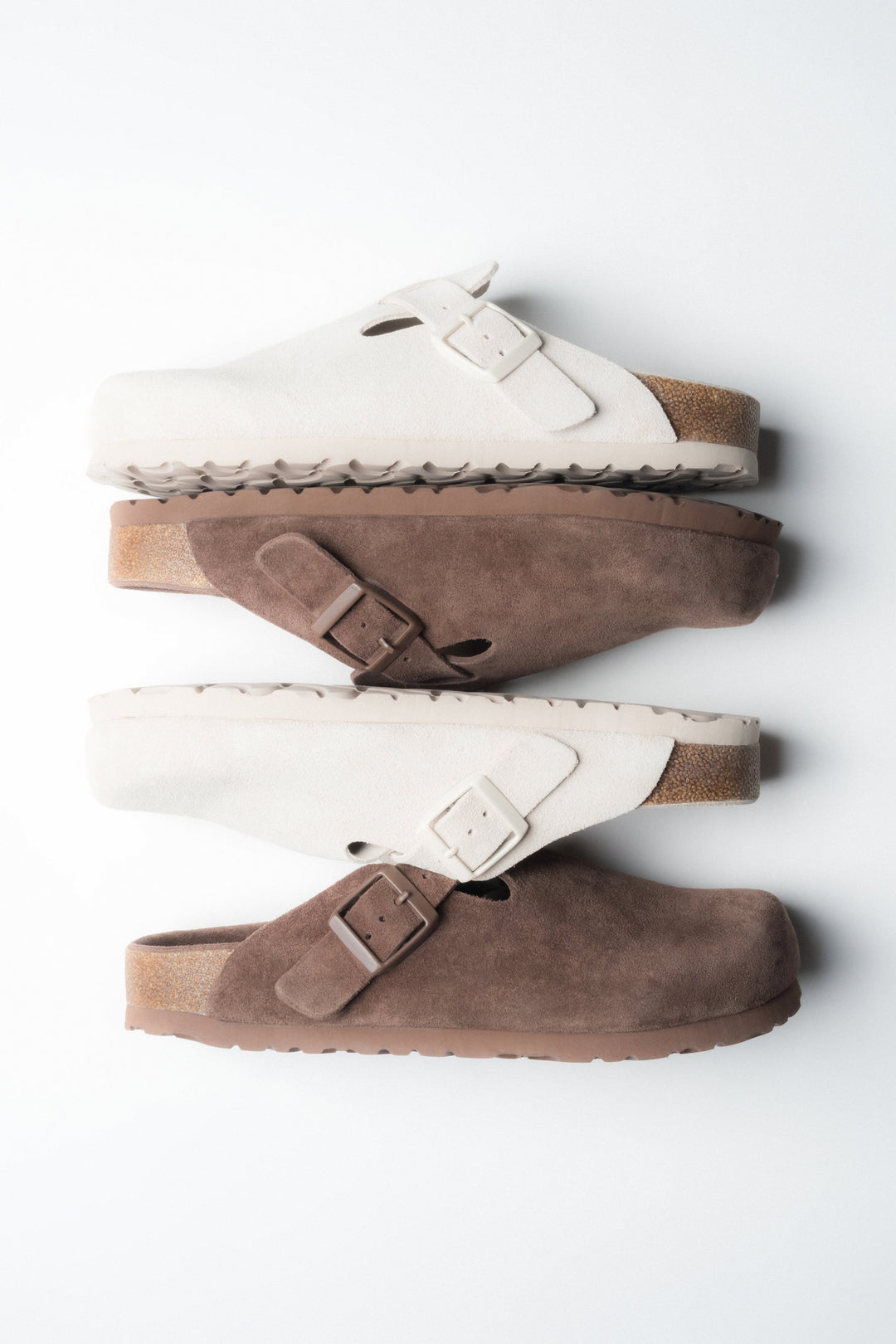 Kombination aus weißen und braunen Damen-Clogs aus weichem Naturvelours.