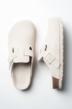 Schräge Draufsicht auf das Paar weißer Damen-Clogs von Estro.