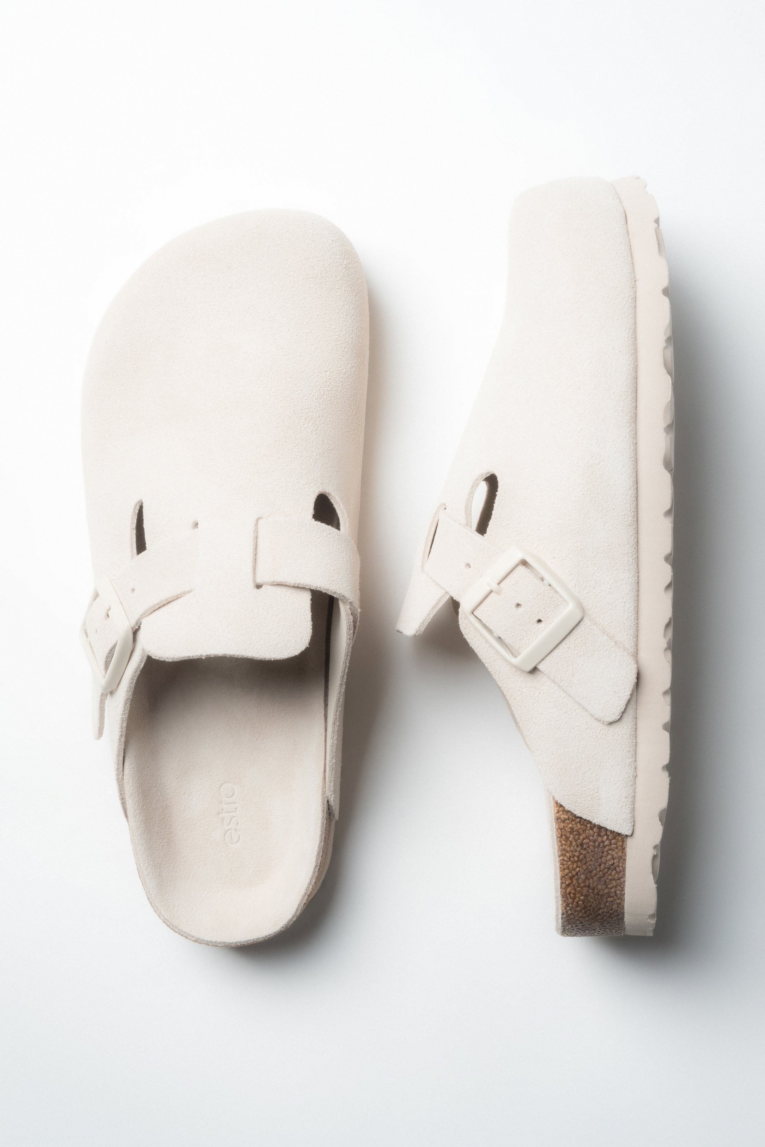 Schräge Draufsicht auf das Paar weißer Damen-Clogs von Estro.