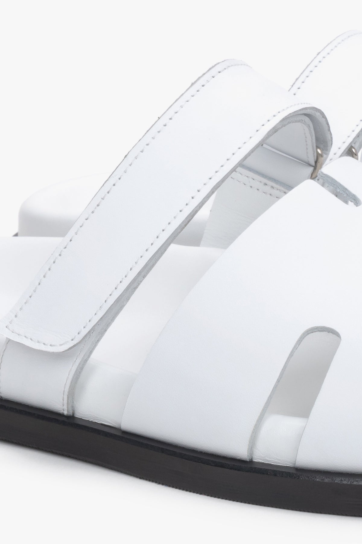Detailaufnahme weißer Damen-Pantoletten aus echtem Leder mit regulierbarem Riemen