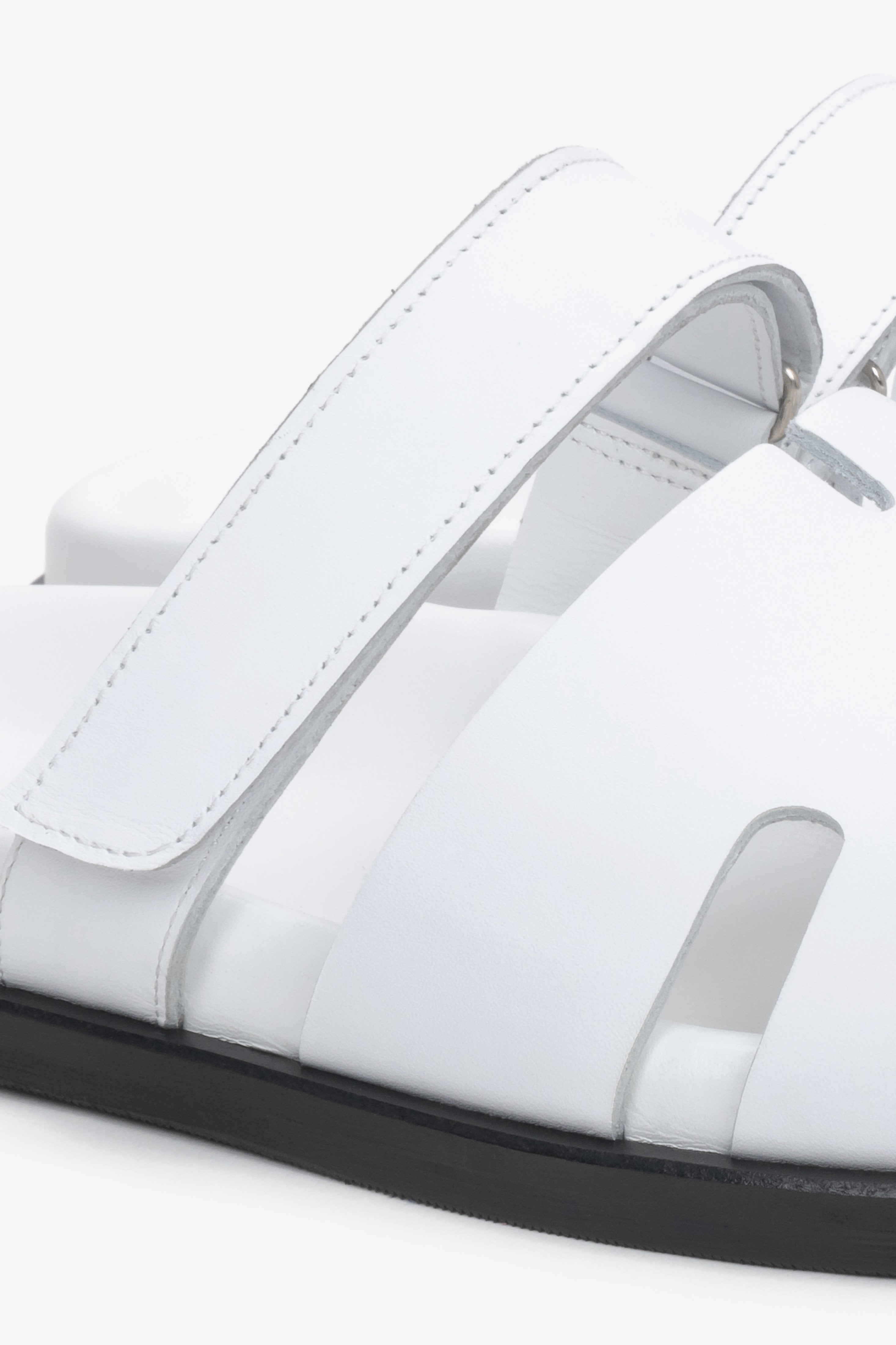 Detailaufnahme weißer Damen-Pantoletten aus echtem Leder mit regulierbarem Riemen