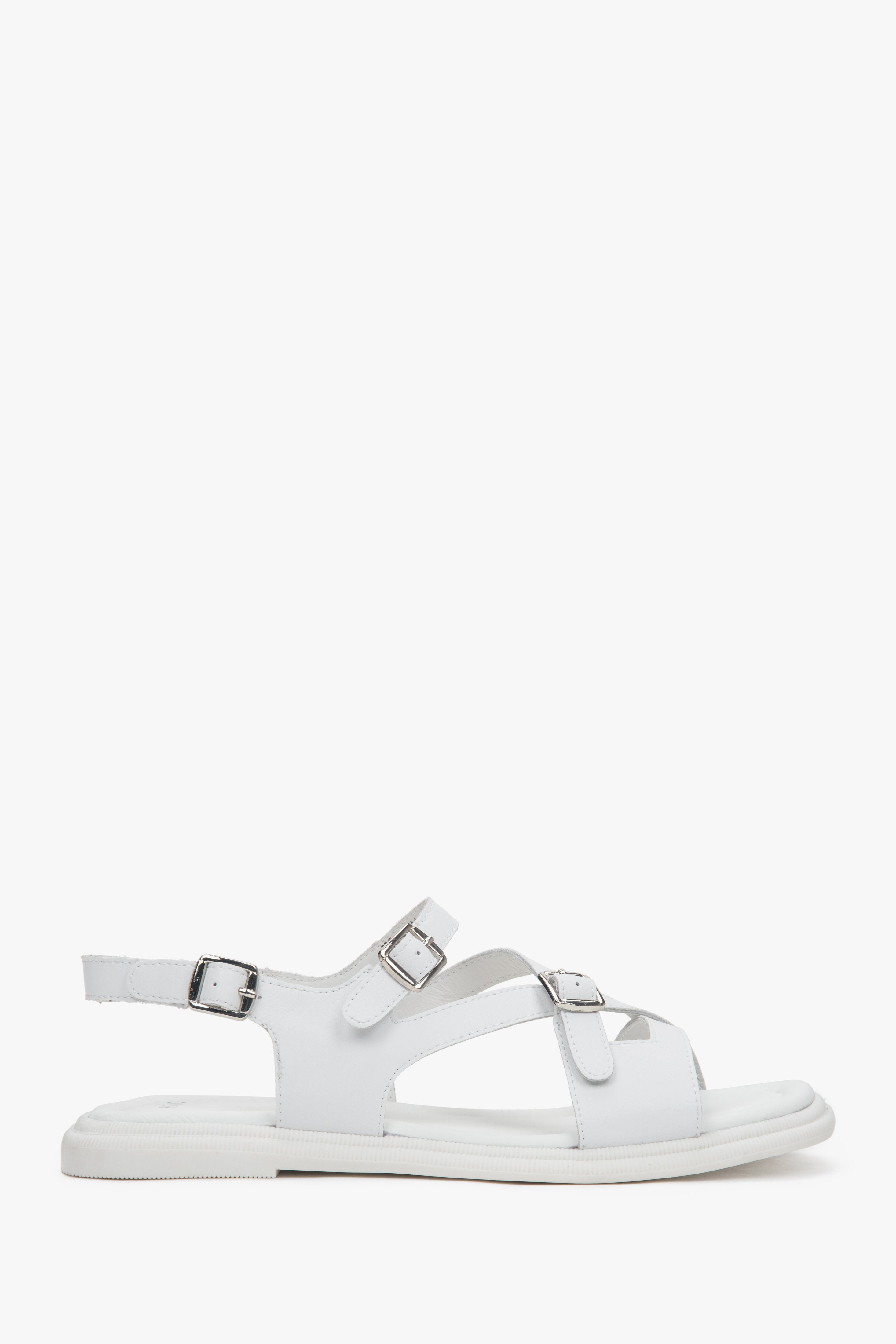 Profilansicht der flachen weißen Damen-Sandalen.
