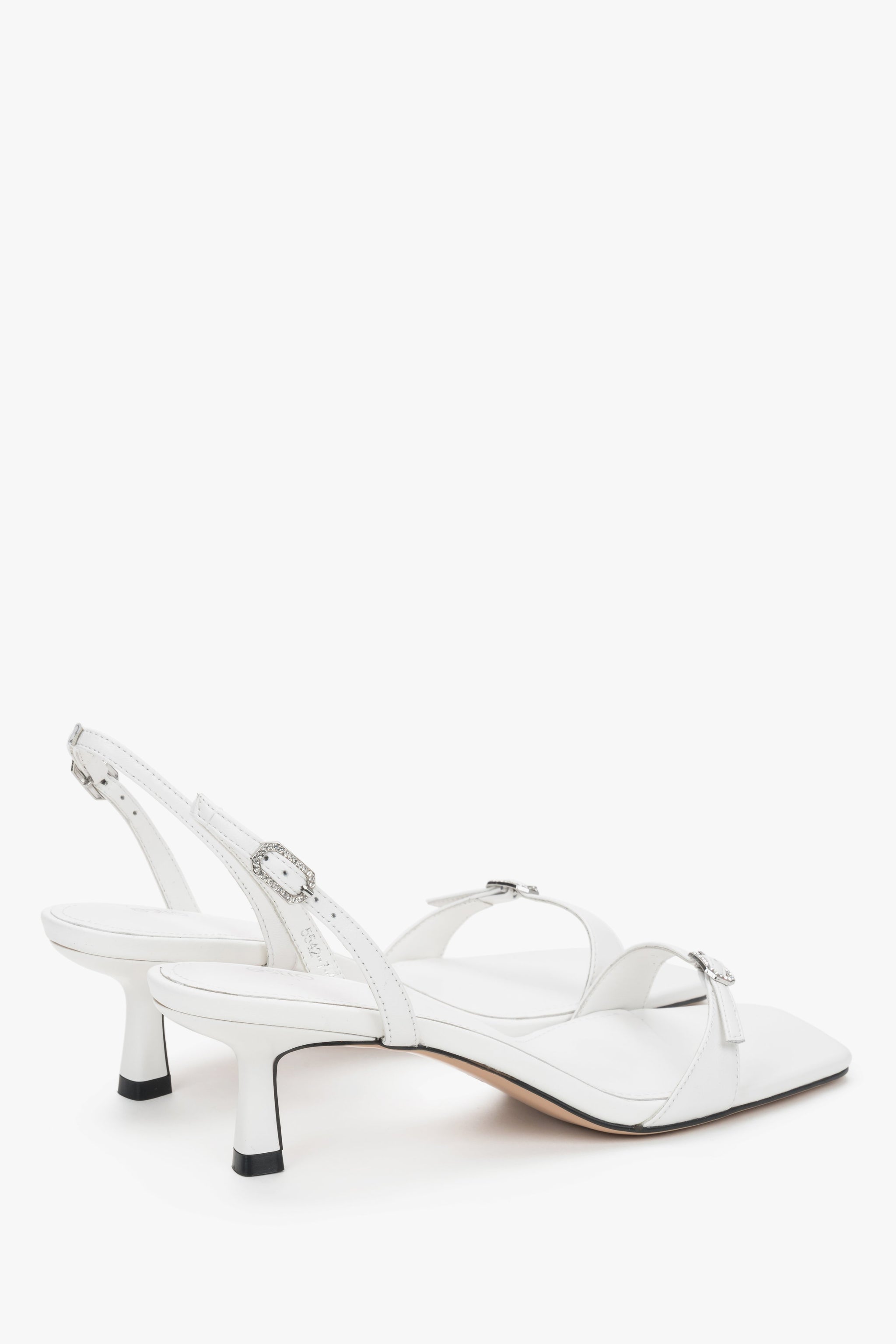 Rückansicht der eleganten weißen Ledersandalen mit verstellbarer Schnalle.