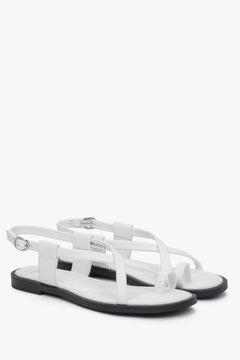 Schräge Seitenansicht der weißen Damen-Sandalen mit Zehenschlaufe und silbernen Details.