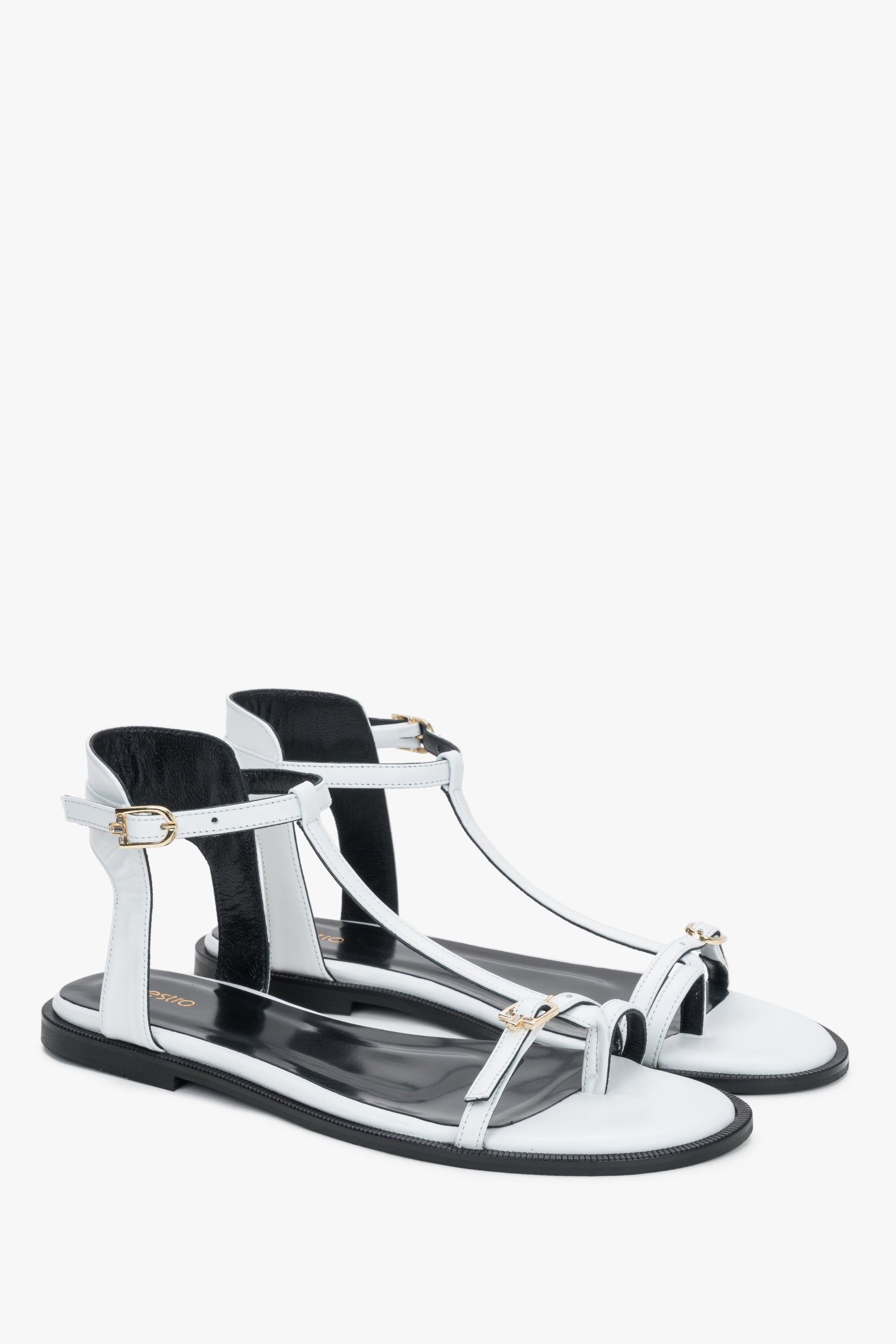 Weiße Damen-Sandalen aus Leder in schräger Vorderansicht mit goldfarbenen Schnallen