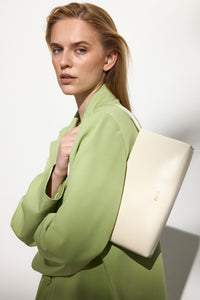 Weiße Damen-Schultertasche aus Leder von Estro getragen von einem Model.
