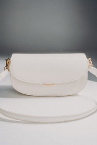 Weiße Damen-Schultertasche aus Leder in Hufeisenform auf grauem Hintergrund.