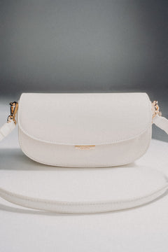 Weiße Damen-Schultertasche aus Leder in Hufeisenform auf grauem Hintergrund.