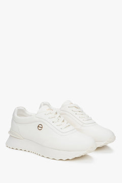 Seitenansicht weißer Sneaker mit flacher Sohle und goldfarbenem Logo – Estro ER00116921
