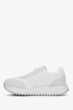 Leicht schräge Seitenansicht des weißen Sneakers mit Schnürung.