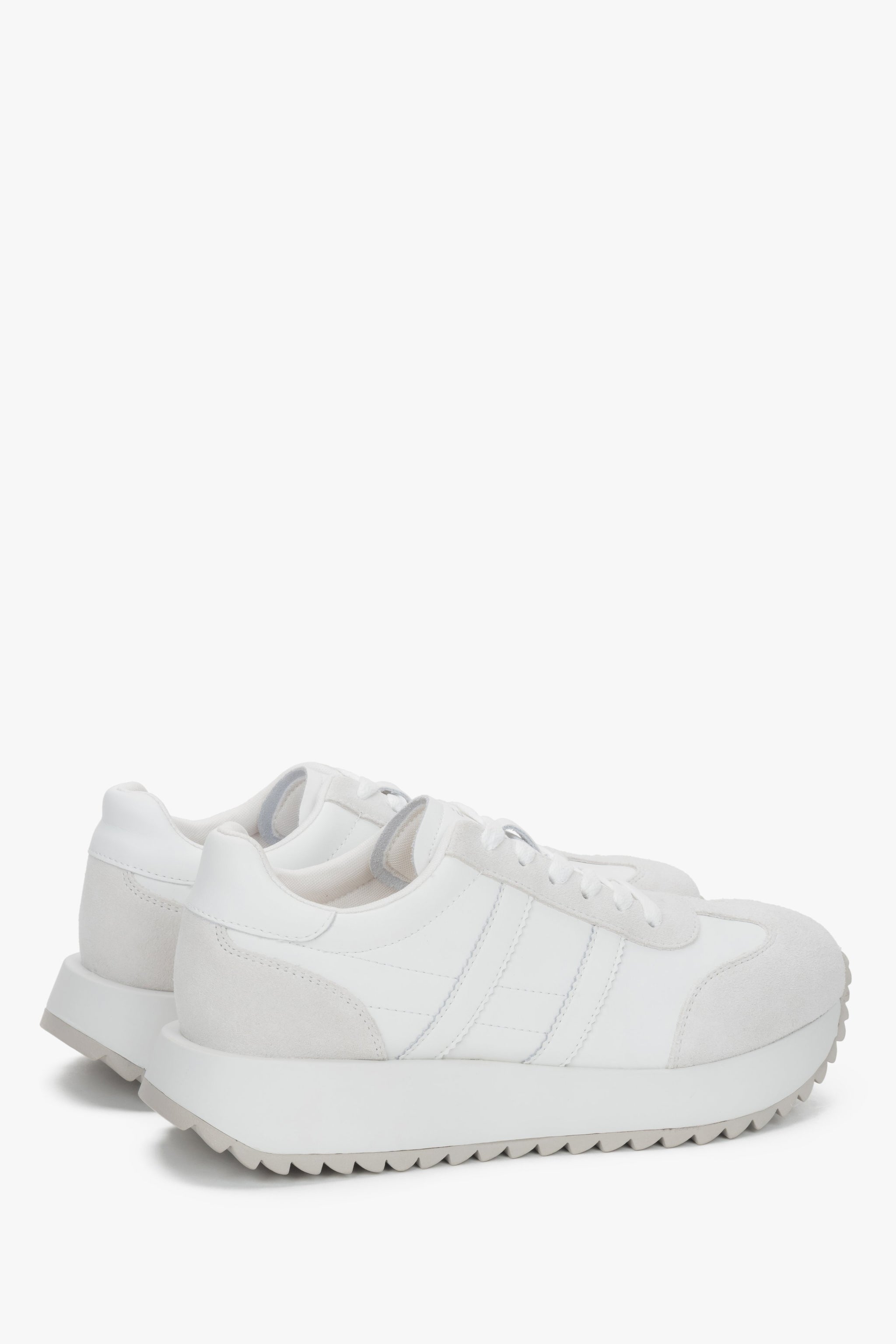 Rückansicht auf das Paar weiße Sneaker, die das Echtlederfutter zeigt.
