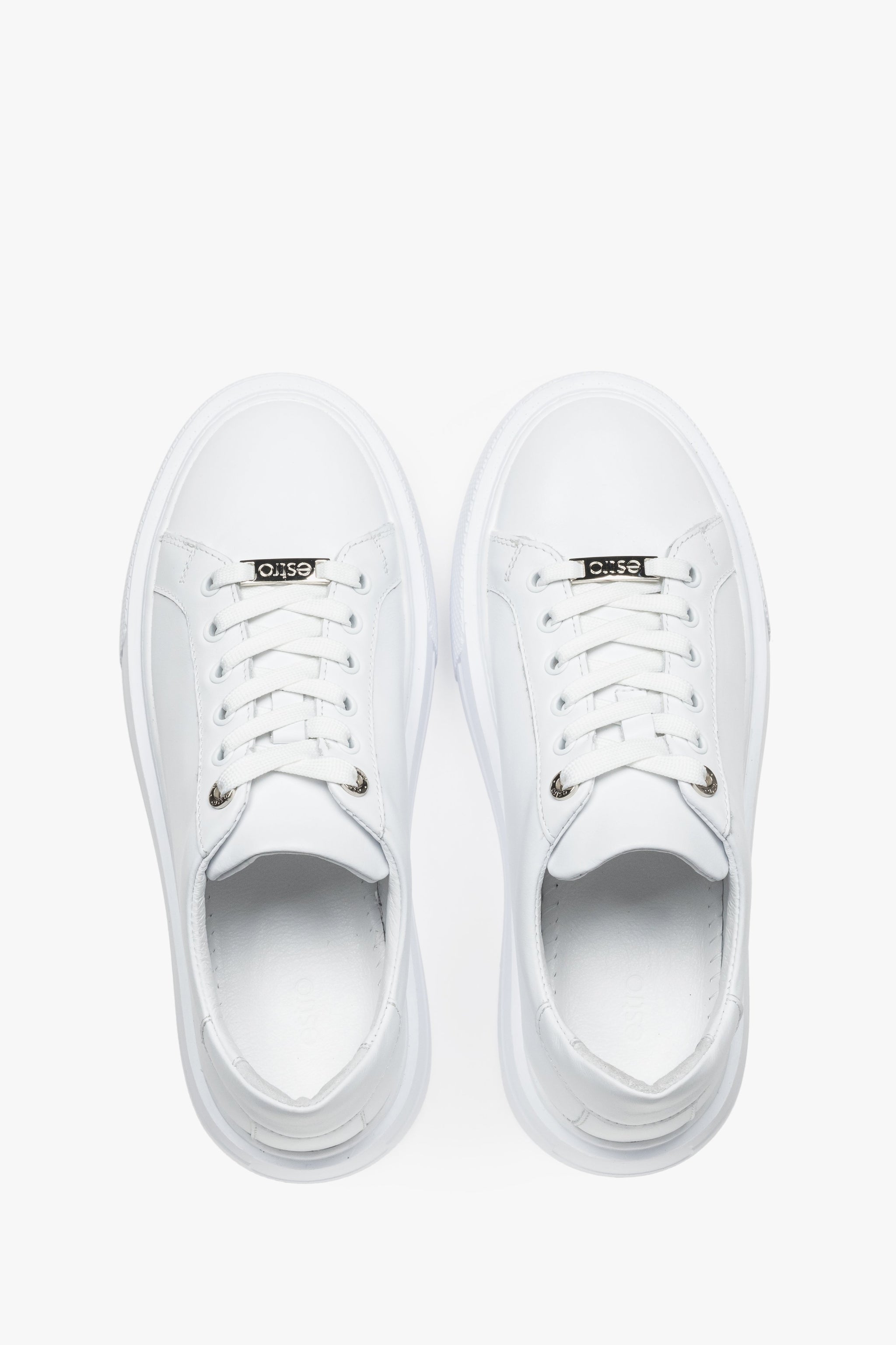 Draufsicht auf das Paar weißer Damen-Sneaker mit Schnürung.