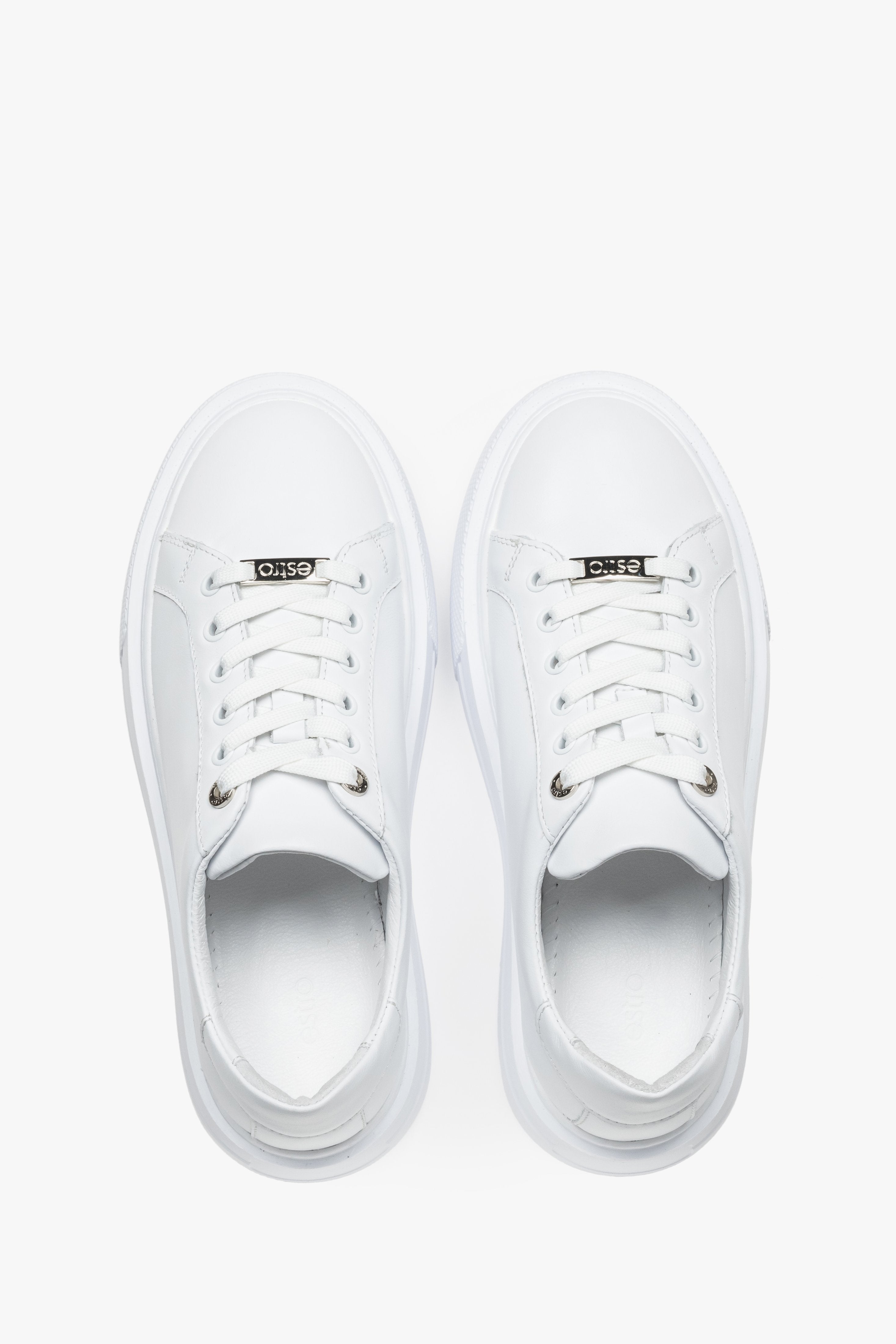Draufsicht auf das Paar weißer Damen-Sneaker mit Schnürung.