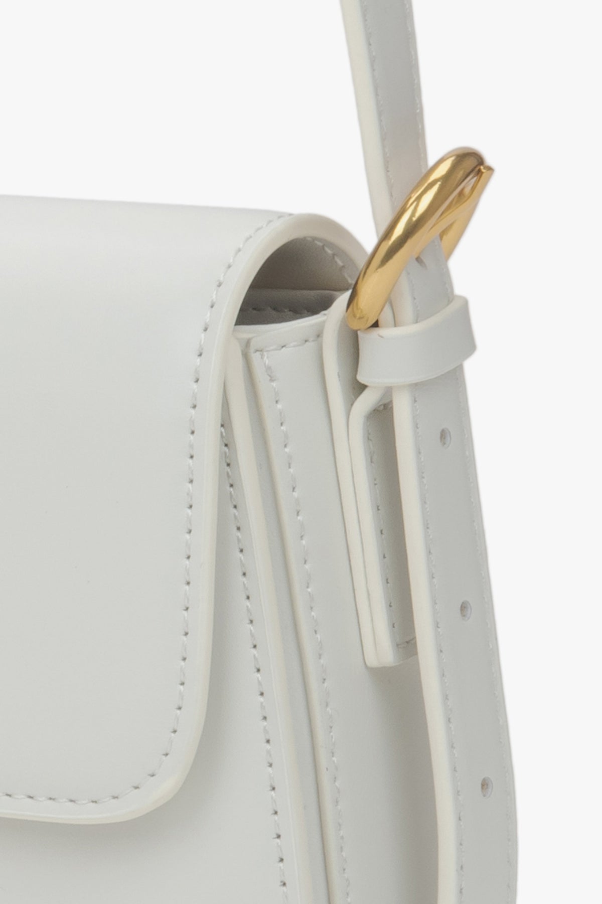 Nahaufnahme der goldfarbenen Beschläge an der weißen Damen-Tasche.