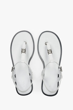 Draufsicht auf die weißen Zehentrenner-Sandalen aus Leder mit silbernen Details und dunkler Sohlenkante